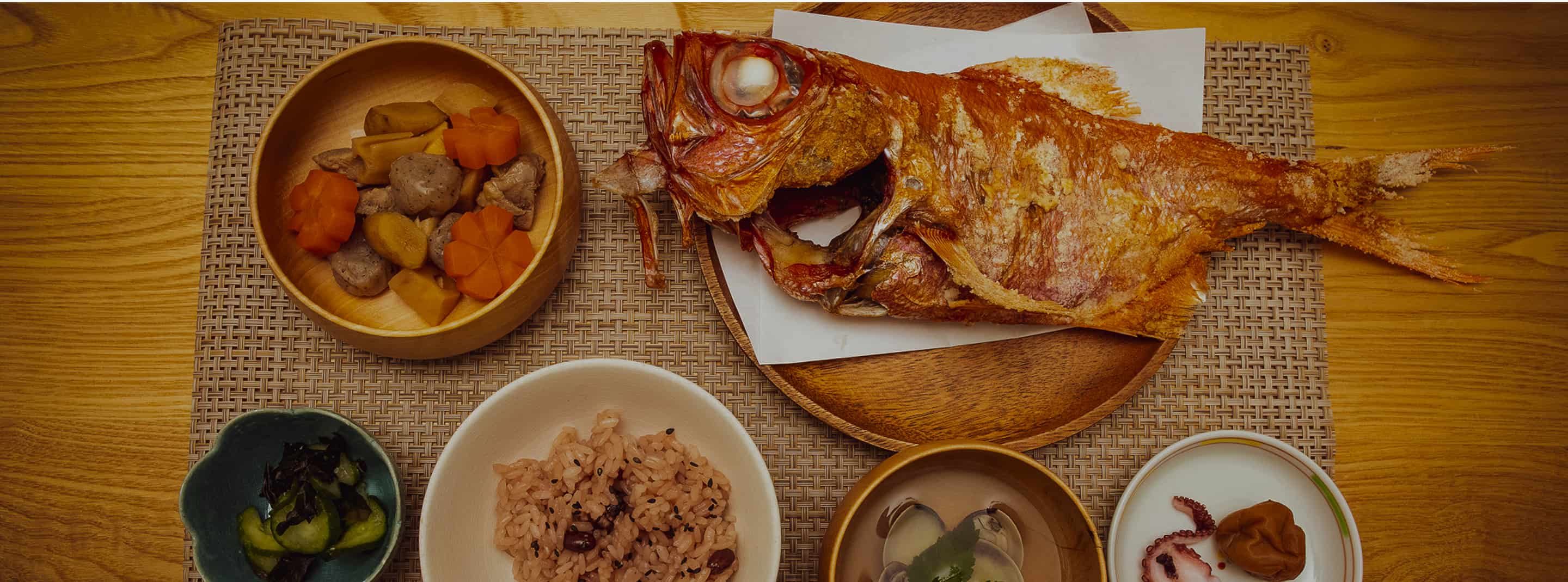 焼いた鯛や赤飯や煮物の画像