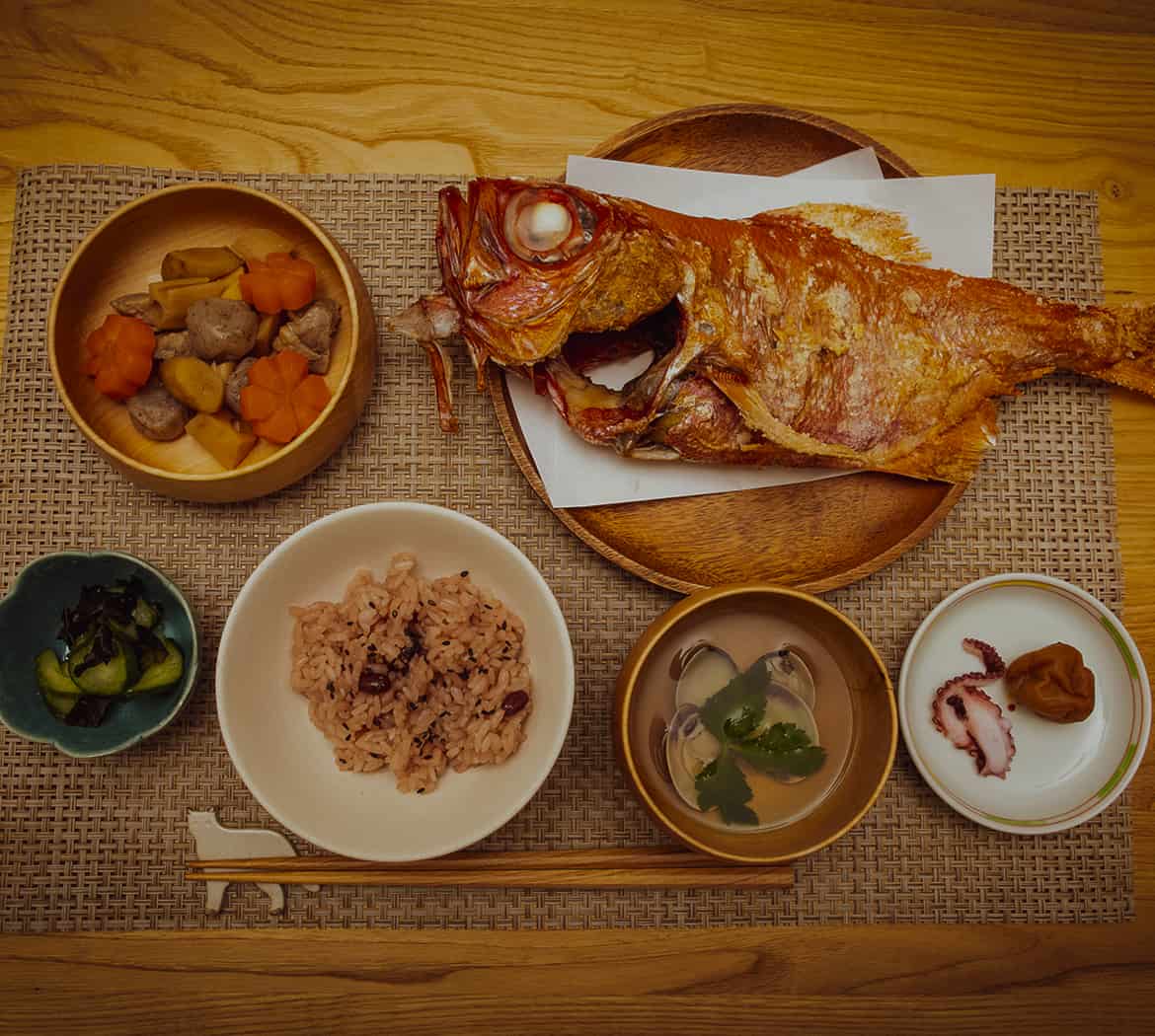 焼いた鯛や赤飯や煮物の画像